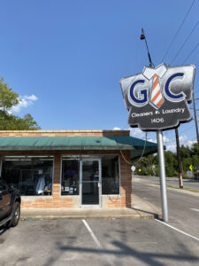 Entrance to the building where GC Cleaners & Laundry is located with their sign and logo that says "GC Cleaners & Laundry" 